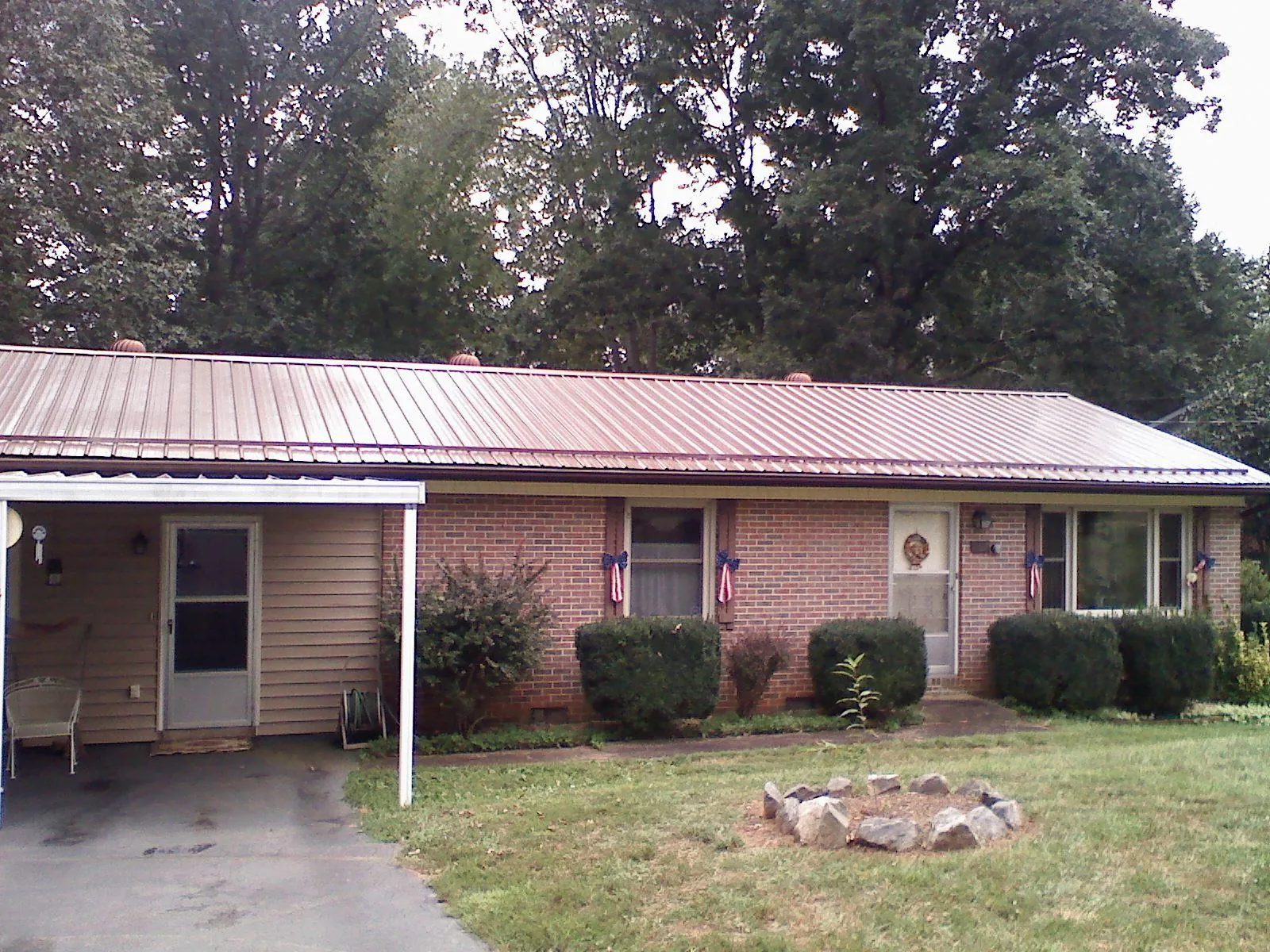 Bronze metal roof and carport on a brick ranch home — Roof Repair work by our crew in Bel Alton